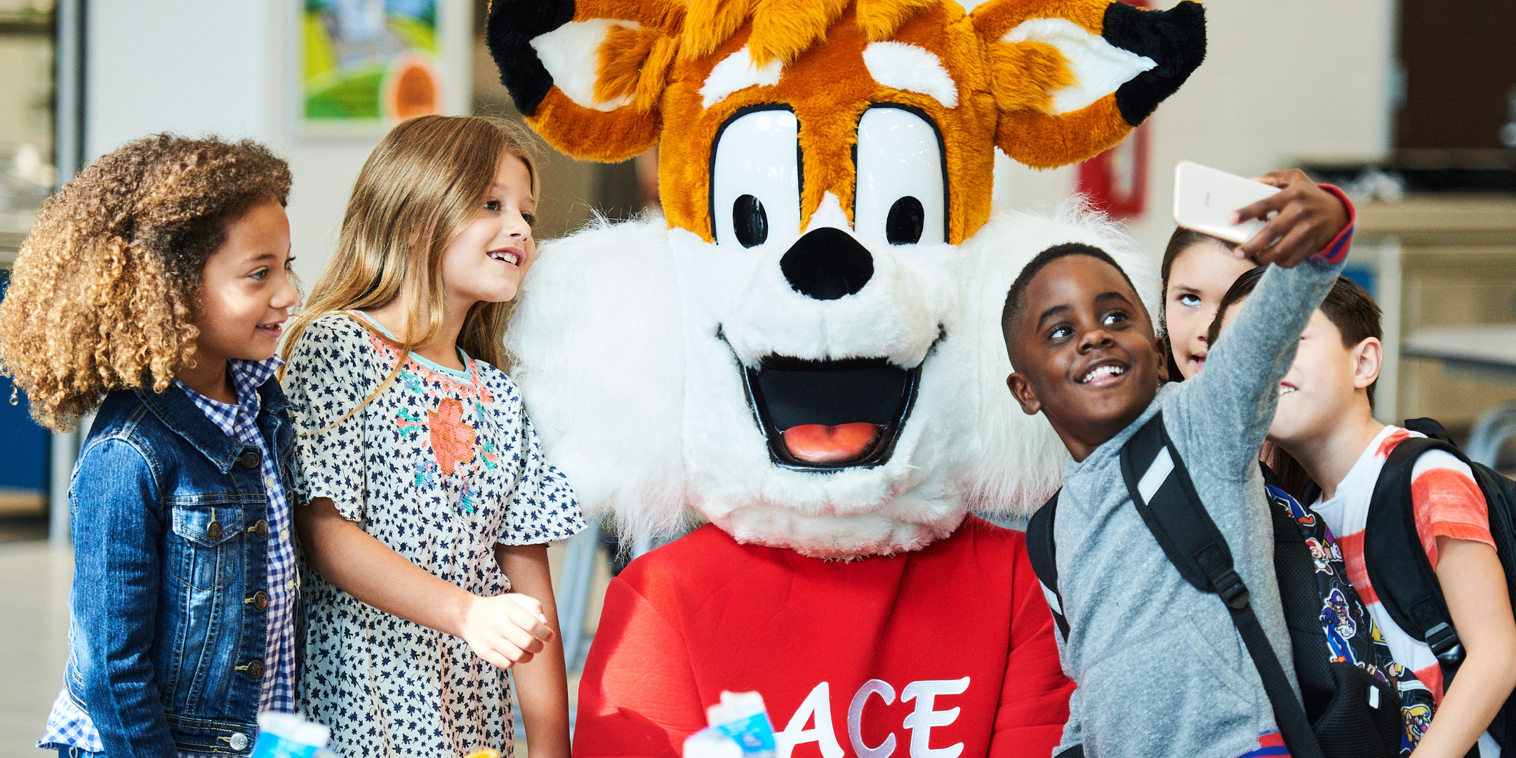 Kids smiling taking picture with fox mascot